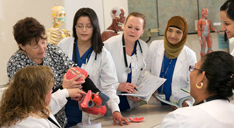 Nursing students taking notes on a hands-on lecture